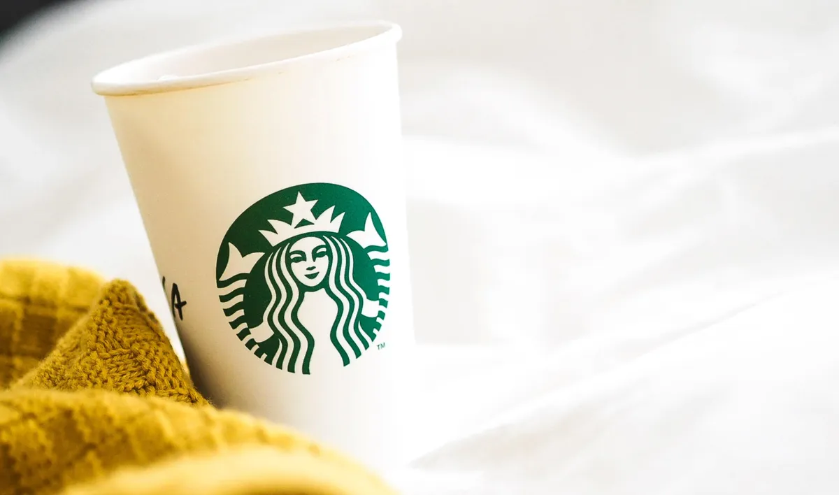 Starbucks coffee cup next to a yellow cloth