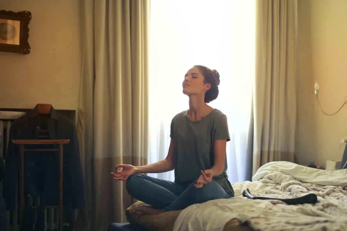 Woman meditating on a bed