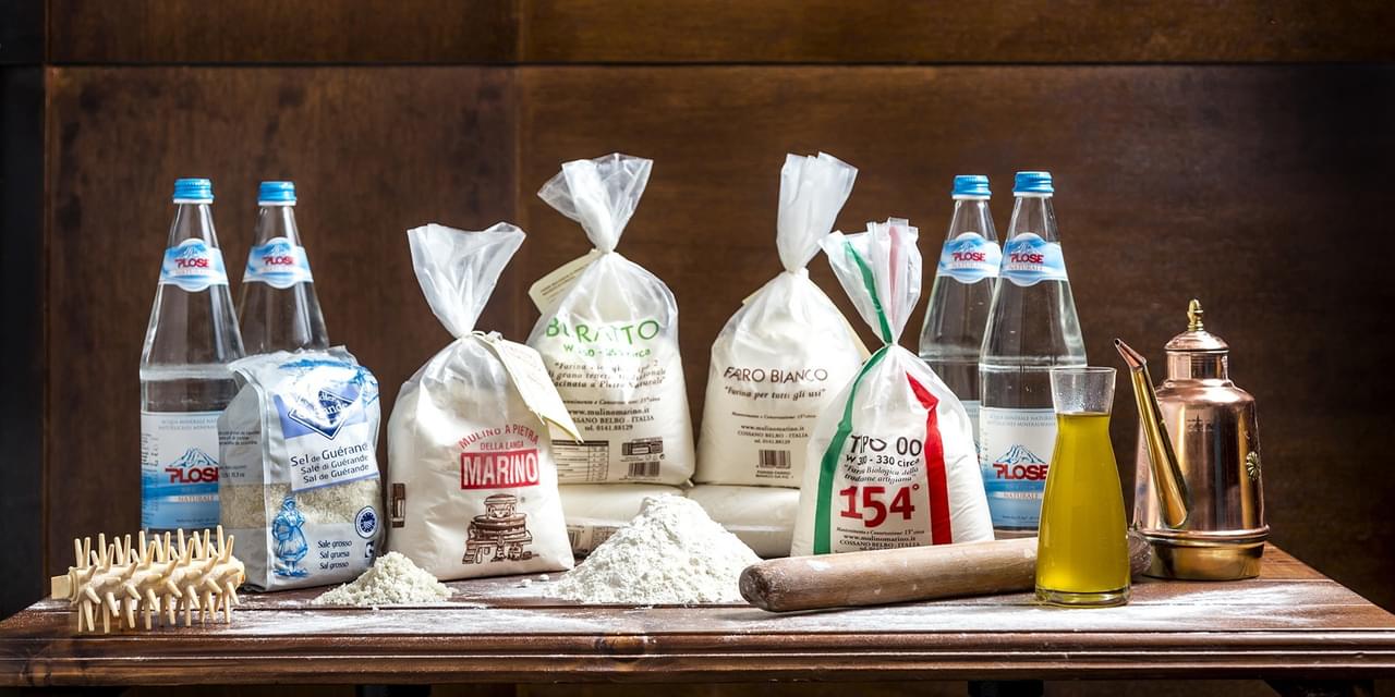A table with various bags of flour and other ingredients.