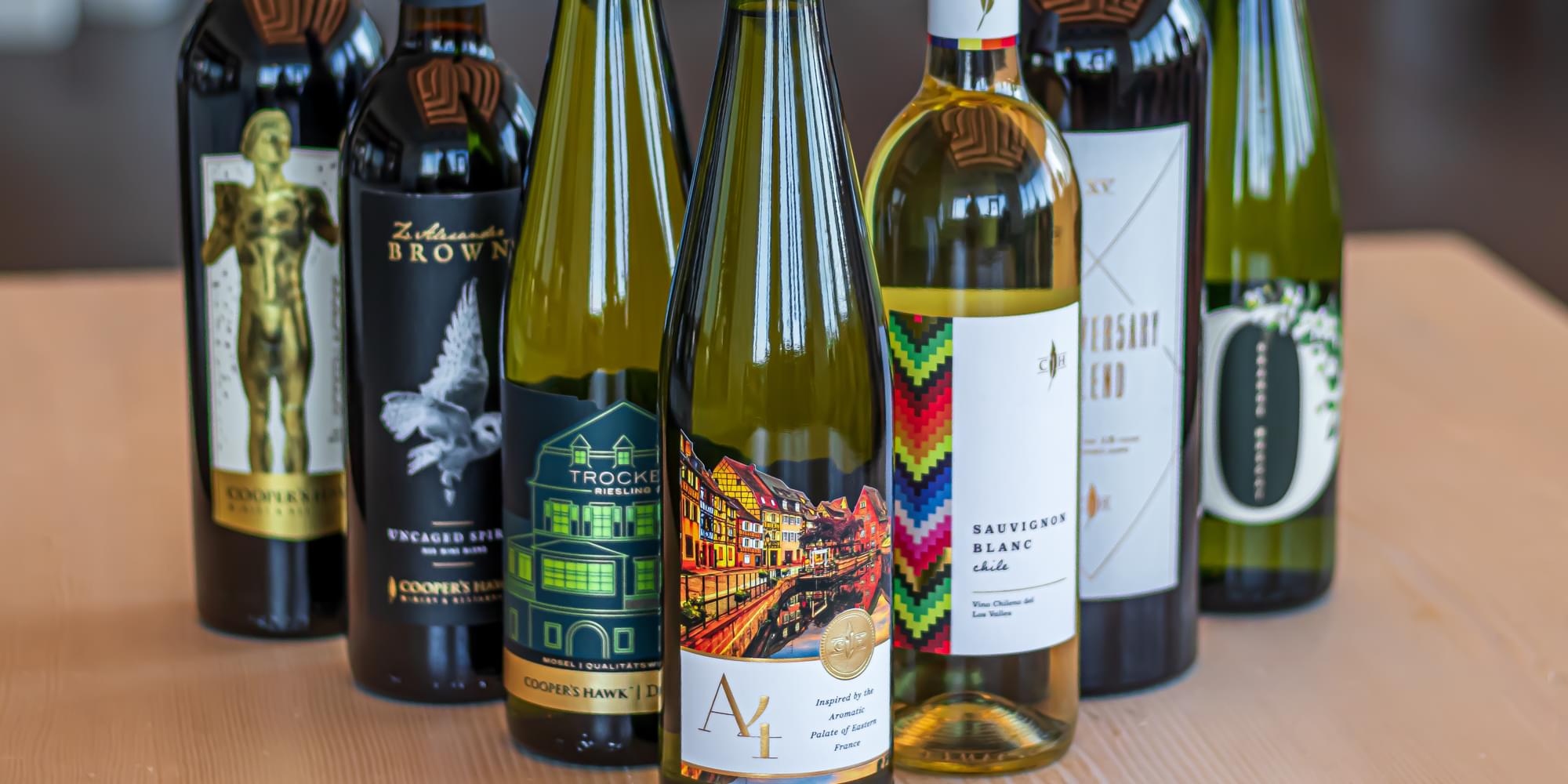 A group of wine bottles lined up on a table.