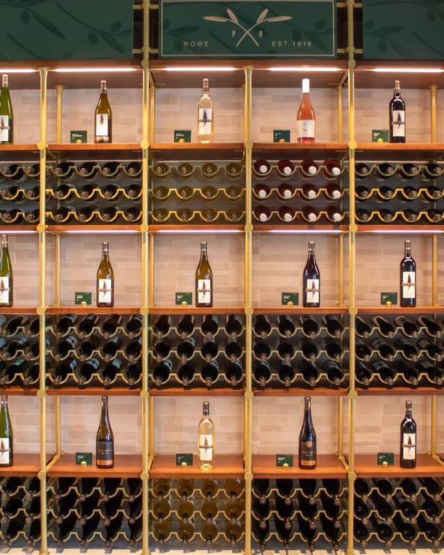 A row of wine bottles on a wooden shelf.