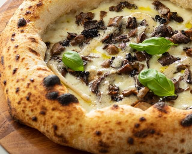 A pizza is sitting on a wooden board.