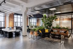 Modern, open concept loft office with modern furniture and high ceilings with exposed beams.