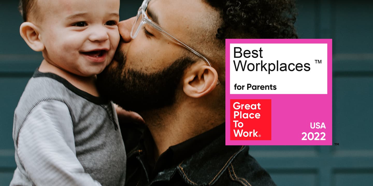A father with glasses holds a toddler and is kissing his cheek with a Great Place to Work Best Workplaces for Parents 2022 badge overlaid.