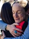 White woman hugs another woman with dark hair