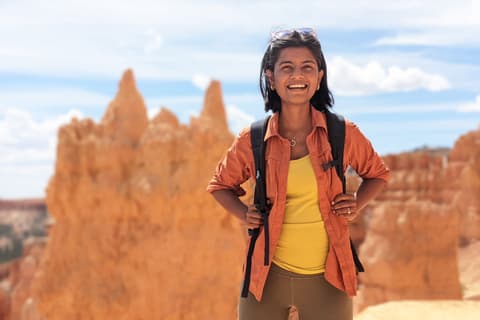Propeller employee Rashi Jaiswal poses in front of a desert landscape with red rock formations on a sunny day. Profile Photo