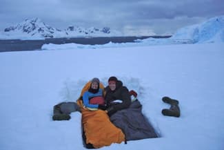 Antarctica camping couple in snow bed