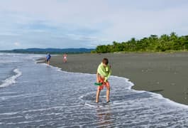 Costa rica osa peninsula casa atrevida boys with grandfather walking on beach