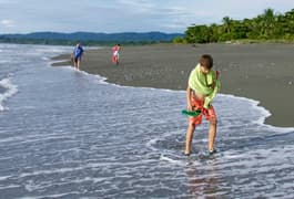 Costa rica osa peninsula casa atrevida boys with grandfather walking on beach