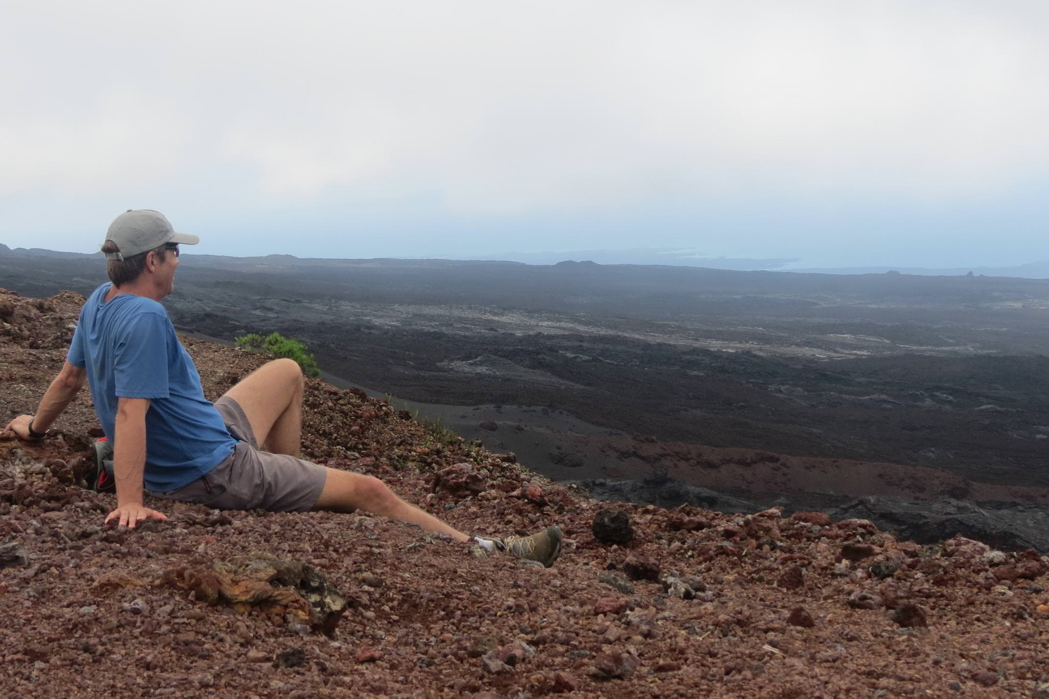 Ecuador galapagos islands isabela cerro negro volcano crater solo man looking out over lava field