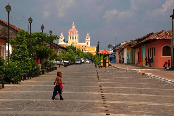 Nicaragua granada small child crossing road in front of cathedral CROPPED