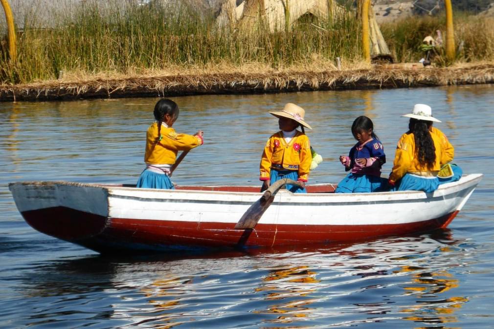 Peru lake titicaca young children dressed in yellow rowing boat20180829 76980 11wvqg6