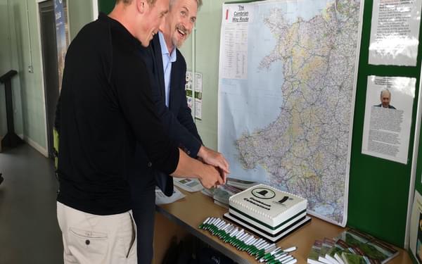 Huw Irranca-Davies and Will Renwick cut the cake at the Cambrian Way launch