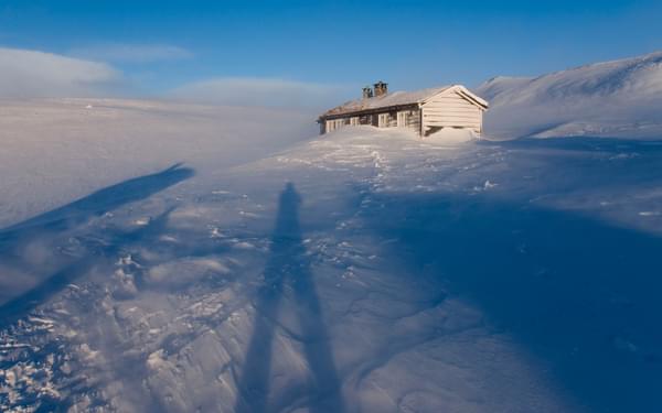 Long winter shadows and the DNT hut in the snow