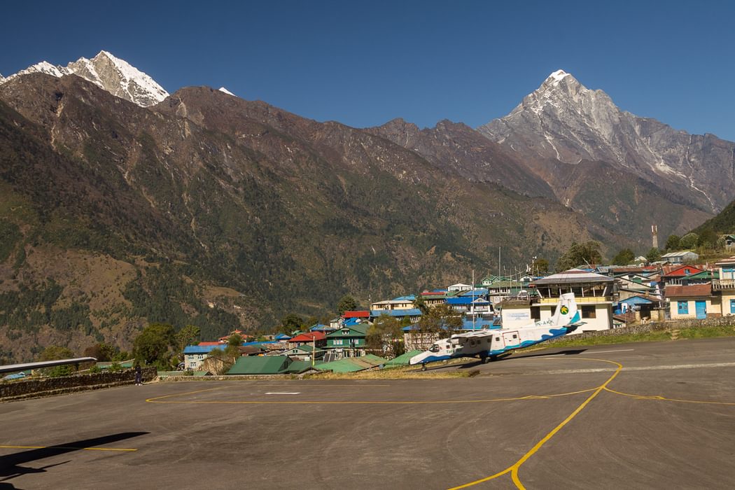 A  Tara  Air  Dornier  Do 228 212 Aircraft Speeds Down The Runway At  Lukla  Airport In The Background Are  Karyolung Left 6511M And  Nupla 5885M