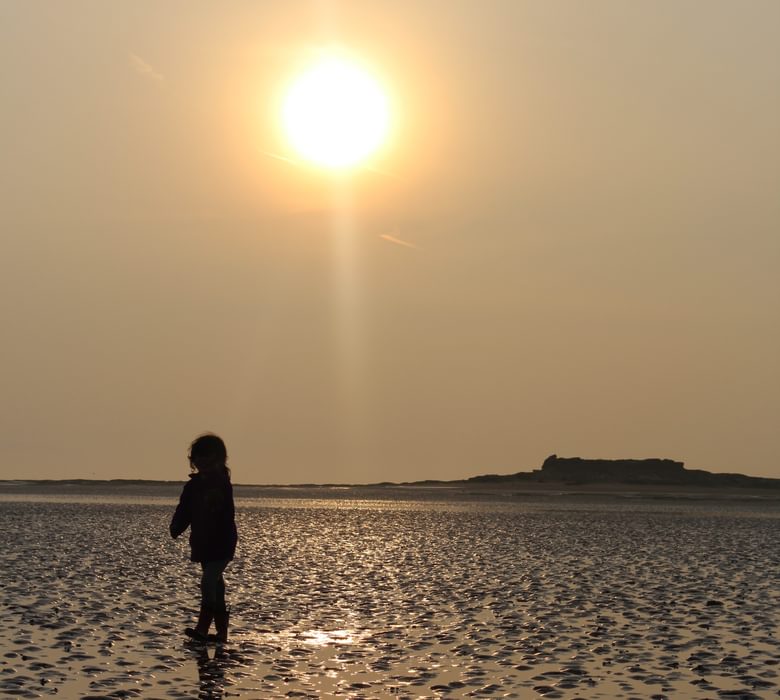 child in sunset on tidal flats