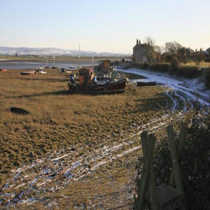Beached boats indicate that the high tide covers the salt marshes at Sunderland Point (Walk 40)