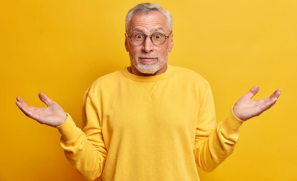 Man shrugging yellow background