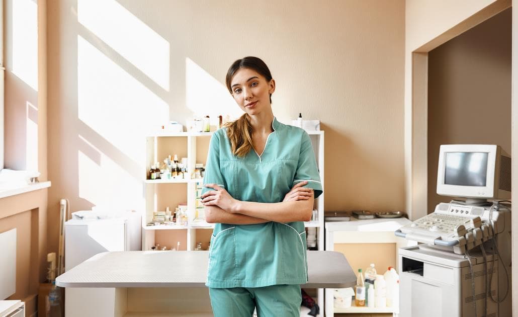 Veterinarian standing in surgery room with arms folded