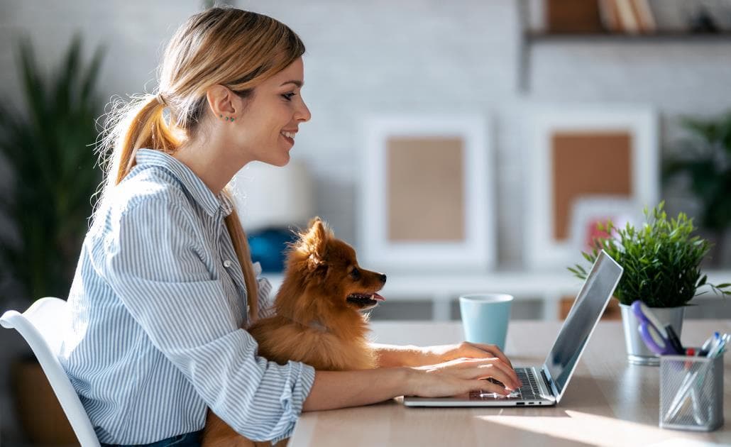 Woman and dog working from home on a laptop