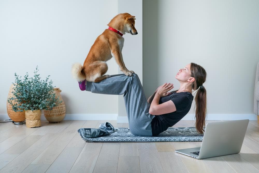 Woman doing yoga with dog