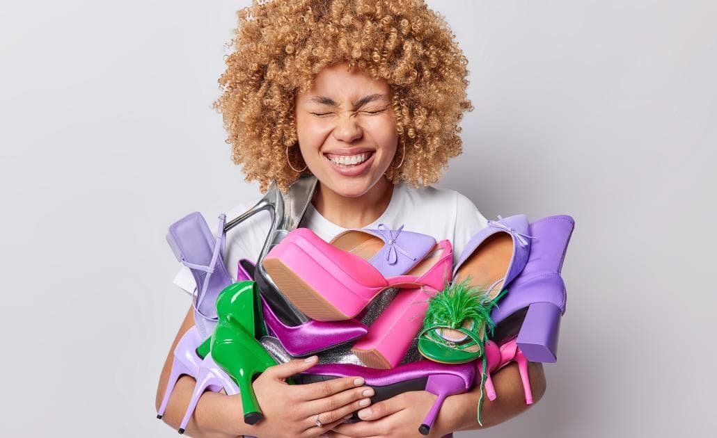 Woman holding bundle of shoes