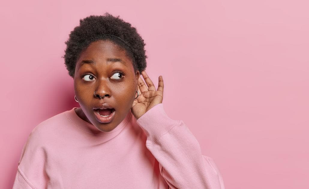 Woman listening pink background