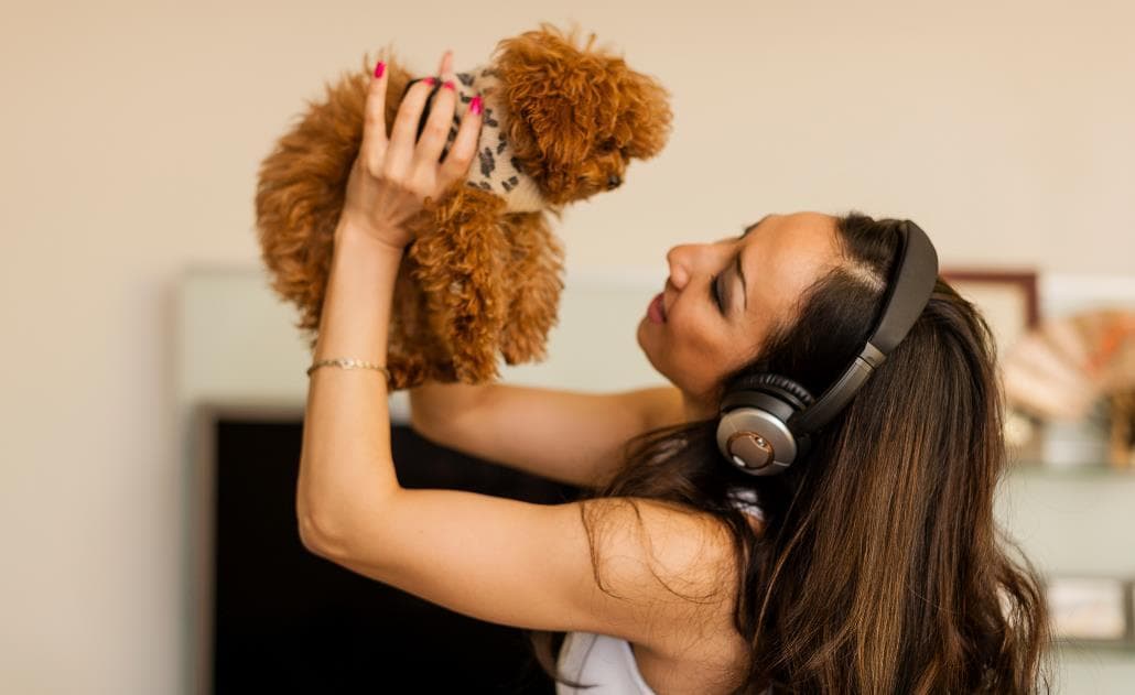 Woman with headphones dancing with dog