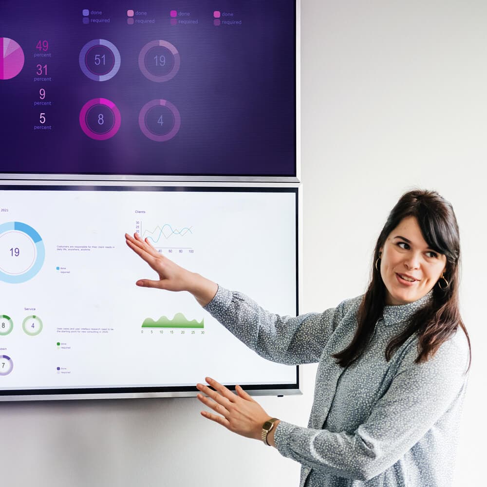 A woman presenting data on a TV screen.