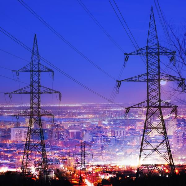Large city at night with electric pylons in foreground