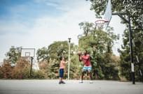 Father and son playing basketball outside.