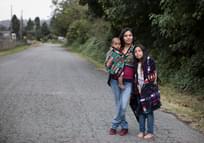 Native American mother, baby, and preteen daughter going for a walk in their neighborhood.
