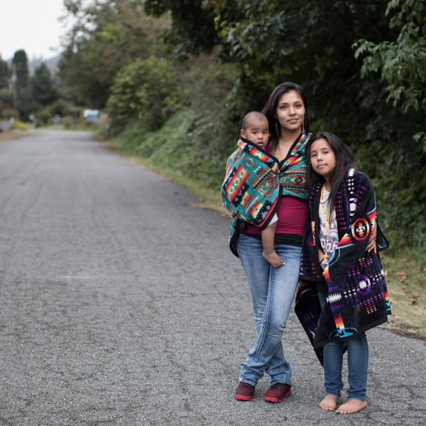 Native American mother, baby, and preteen daughter going for a walk in their neighborhood.