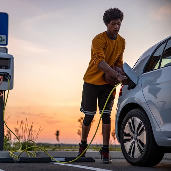 Young man charging his electric vehicle (EV) with EVSE
