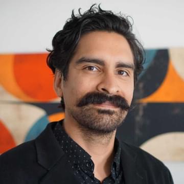 Close-up portrait of Noe Mateos inside an office building.