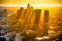 The downtown buildings of Los Angeles, California, silhouetted by the sunset with rays of sun reflecting off the haze