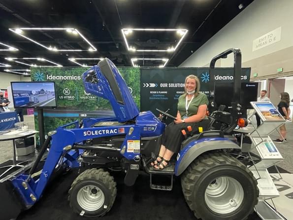 Resource Innovations employee sitting on an electric tractor (EV)