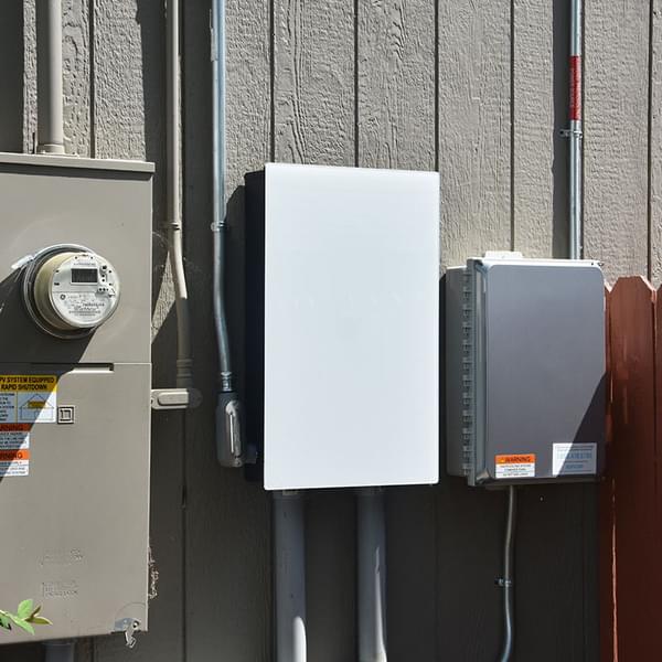 Installed residential battery storage system mounted on exterior wall of a home