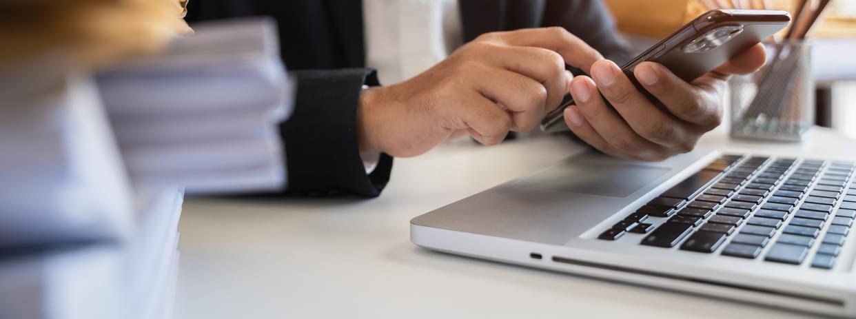 Man using smartphone and laptop