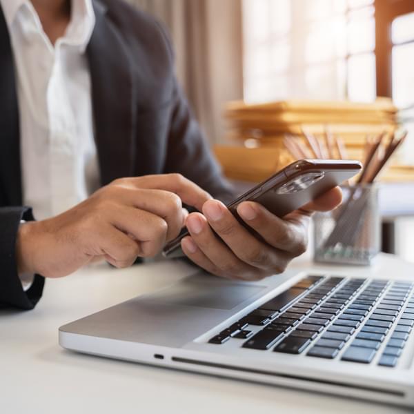 Man using smartphone and laptop