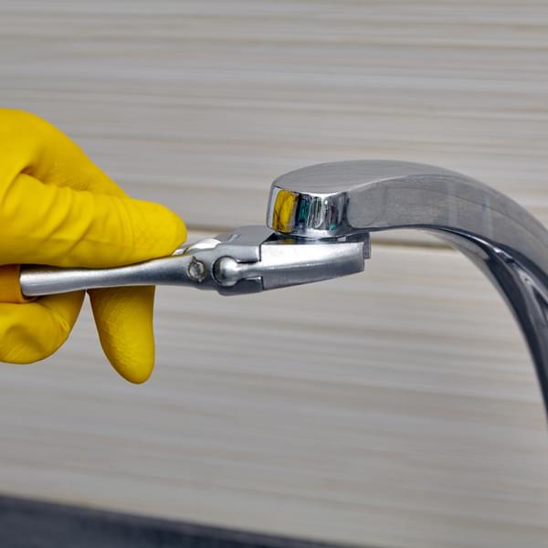 Contractor installing faucet aerator on faucet.