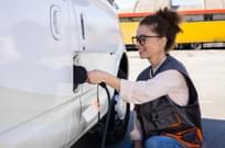 Female worker charging an electric fleet vehicle.