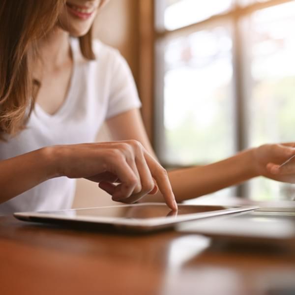 Shopping online, Woman using tablet and holding credit card on table.