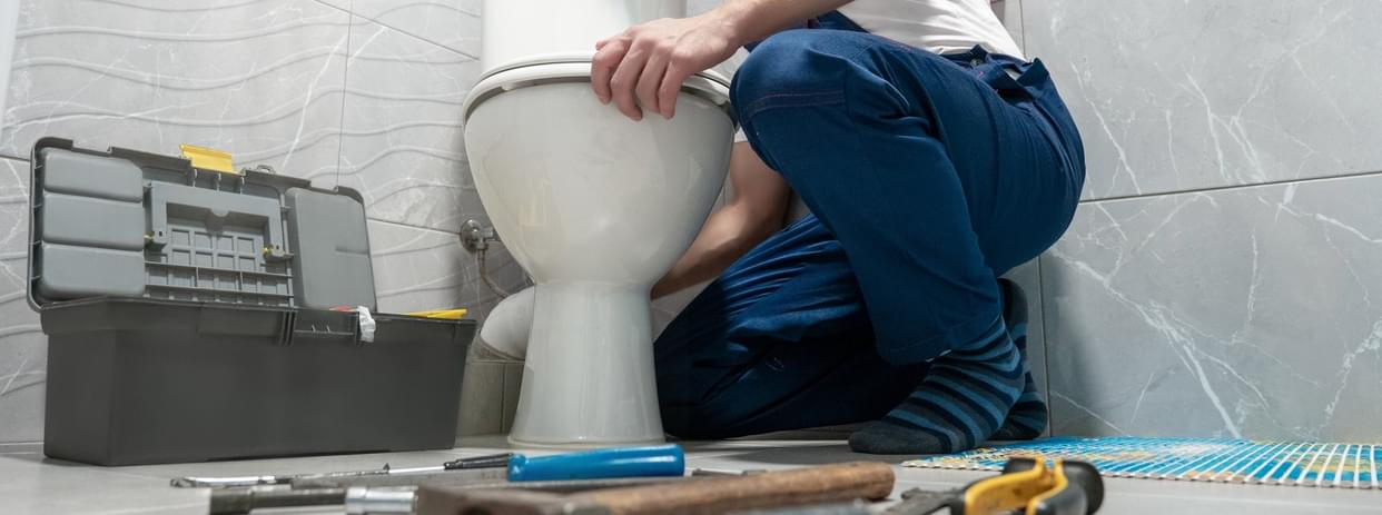 Contractor installing a high-efficiency toilet in bathroom.