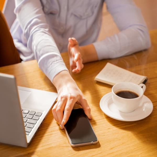 High angle view of hand reaching for phone.