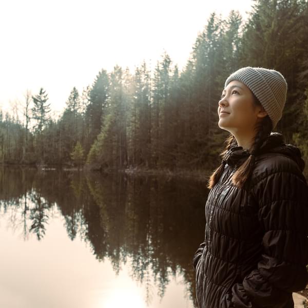 Woman in contemplation beside a lake.