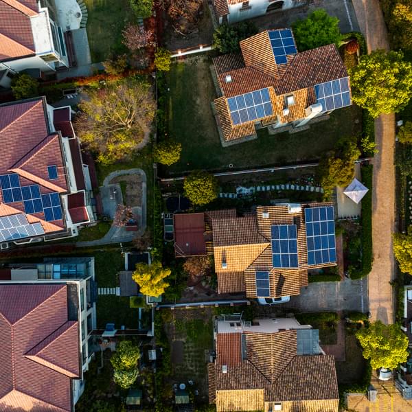 Modern houses with distributed energy resources and solar panels for energy storage.