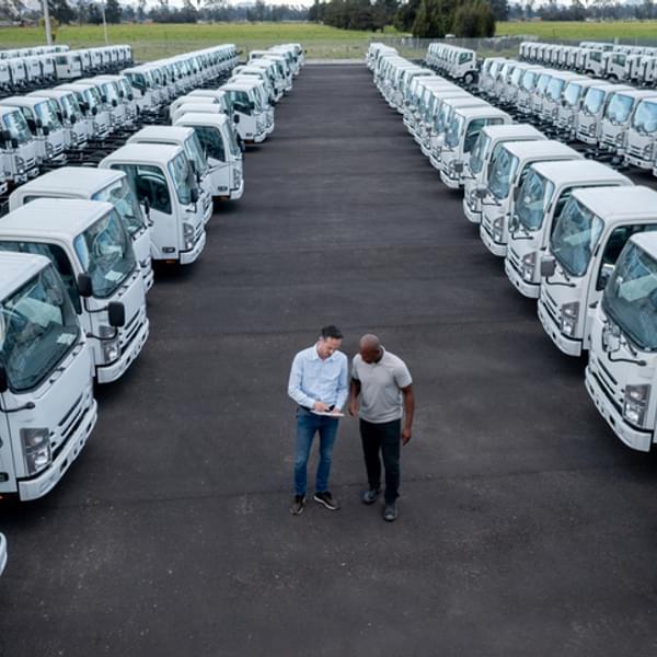 EV assessment expert talking to a client in parking lot full of vans.