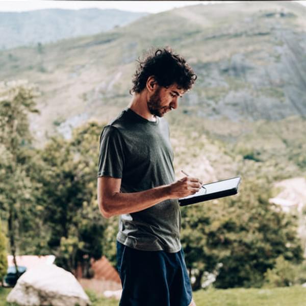 Man using digital tablet in the mountains.