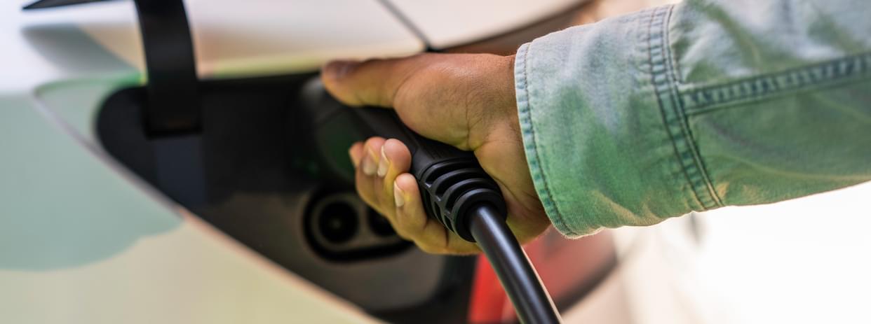 Man holding an electric car charger